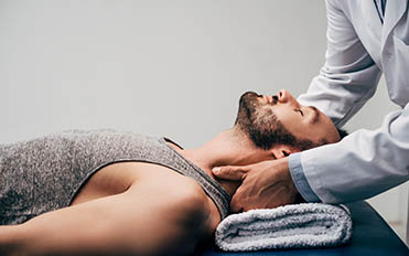 chiropractor adjusting neck of an injured man